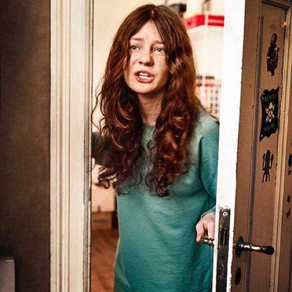 Fotografi: En tonårstjej står i dörröppningen till sitt rum. Hon är på väg att smälla igen dörren.